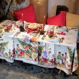 Tovaglia natalizia Schiaccianoci in puro lino di Tessitura Toscana Telerie. Fantasia piazzata su fondo chiaro, con abeti addobbati, regali e giocattoli che richiamano l'atmosfera del Natale. Misura rettangolare 170x270 cm.