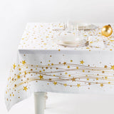 Tovaglia natalizia Gold di Caleffi. Stampa digitale su panama di puro cotone.  Fantasia su fondo bianco con stelle, righe e sfere dorate che richiamano l'atmosfera del Natale. Tovaglia rettangolare per 12 persone.