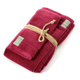 Asciugamano con ospite Coccola Fazzini. Coppia asciugamani in tinta unita. Colore rubino rosso bordeaux. Spugna di cotone 550 g/mq.