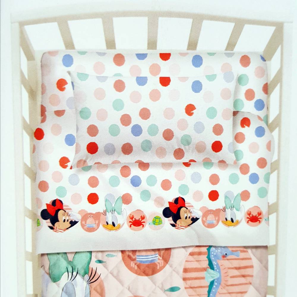 Completo lenzuola per culla Baby Minnie di Caleffi Disney.   Fantasia con Minnie e Paperina, fondo bianco con pois colorati, ideale per la tua bambina.