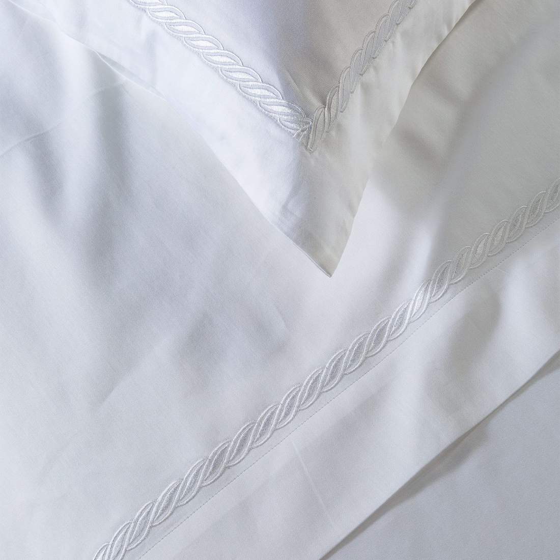 Completo lenzuola matrimoniale Caleffi Treccia, in raso di puro cotone. Il completo lenzuola Treccia è in tinta unita bianca, con elegante ricamo bianco a forma di treccia
