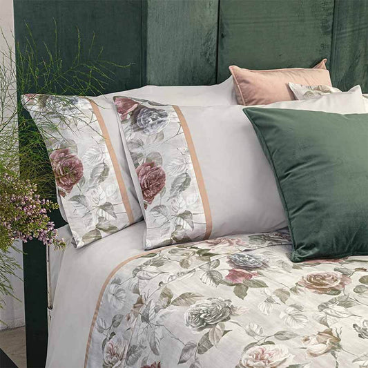 Completo lenzuola matrimoniale Fazzini Rugiada in flanella di puro cotone.  Le federe e il lenzuolo di sopra presentano una fascia stampata con fantasia floreale con rose rosse e azzurre su fondo bianco ghiaccio, rifinita da fascetta a contrasto. Il resto del completo è in tinta unita grigio/avio chiaro.