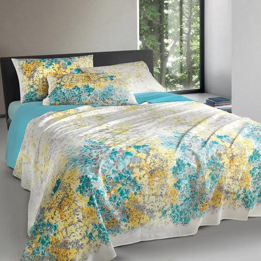 Lenzuolo Copriletto Naxos di Gabel in puro cotone. Disponibile per letto matrimoniale.  Il completo lenzuola Naxos presenta una vivace fantasia floreale con petali gialli e azzurri. Il lenzuolo di sopra e le federe double face sono in fantasia. Il lenzuolo con angoli è in tinta unita azzurro.