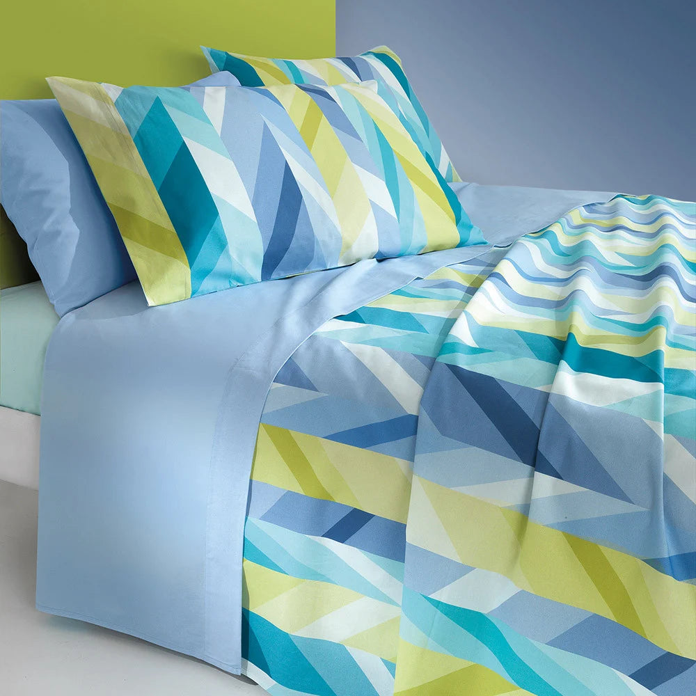 Lenzuolo Copriletto Tahiti di Gabel in puro cotone. Disponibile per letto singolo e piazza e mezza maxi (misura francese).  Il lenzuolo di sopra e la federa presentano una fantasia geometrica e moderna, sui toni del verde e del blu. Il lenzuolo con angoli è in tinta unita color azzurro