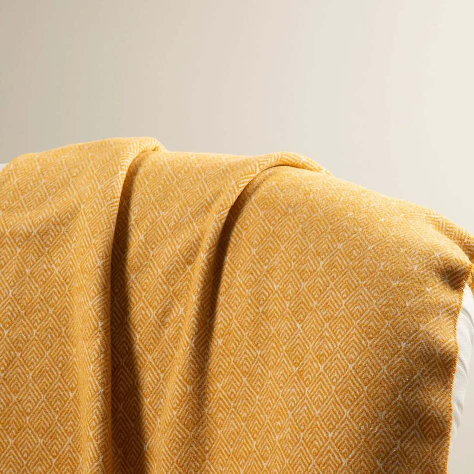 Il plaid Caleffi Cortina è realizzato in morbidissimo cotone caldo. E' caratterizzato da una stampa spigata a rombi molto discreta, che lo fa sembrare quasi un plaid tinta unita. Colore giallo oro. Dettaglio fantasia.