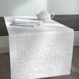 Runner Isabelle di Somma, in twill di puro cotone stampato.  Il set include una corsia rettangolare (50x150 cm) e due tovaglioli stampati (45x45 cm).  Corsia con fantasia floreale tono su tono, foglie bianche su fondo chiaro.