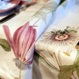 Tovaglia Granadilla in puro lino stampato. Realizzata in Italia da Tessitura Toscana Telerie. La tovaglia Granadilla presenta una fantasia floreale su fondo avorio, con fiori rosa e foglie verdi a contrasto. Tovaglia rettangolare per 8 o 12 persone