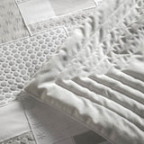 Trapunta invernale matrimoniale Cristalli di Fazzini in raso di puro cotone. Piumone medio tepore. Fantasia geometrica colore bianco seta/avorio/beige. Dettaglio.