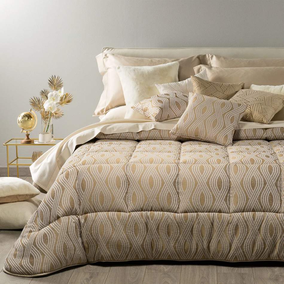 Trapunta invernale matrimoniale Caleffi Abbraccio, in prezioso raso jacquard. Trapuntata a capo e rifinita con angoli arrotondati. Piumone con fantasia moderna dalle forme morbide. Colore oro.