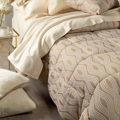 Trapunta invernale matrimoniale Caleffi Abbraccio, in prezioso raso jacquard. Trapuntata a capo e rifinita con angoli arrotondati. Piumone con fantasia moderna dalle forme morbide. Colore oro.