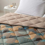 Trapunta invernale Caleffi Cosmo. Disponibile nella misura per letto singolo, piazza e mezza e matrimoniale. Fantasia geometrica multicolore dallo stile moderno,con forme che ricordano pianeti ed eclissi.