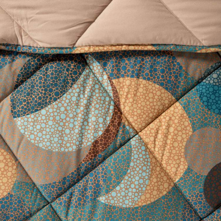 Trapunta invernale Caleffi Cosmo. Disponibile nella misura per letto singolo, piazza e mezza e matrimoniale. Fantasia geometrica multicolore dallo stile moderno,con forme che ricordano pianeti ed eclissi. Dettaglio fantasia