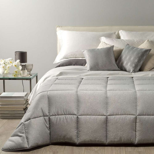 Trapunta invernale matrimoniale Caleffi Samoa, in prezioso raso jacquard. La trapunta Samoa è caratterizzata da una microfantasia puntinata, che è la perfetta via di mezzo tra fantasia e tinta unita. piumone colore grigio.