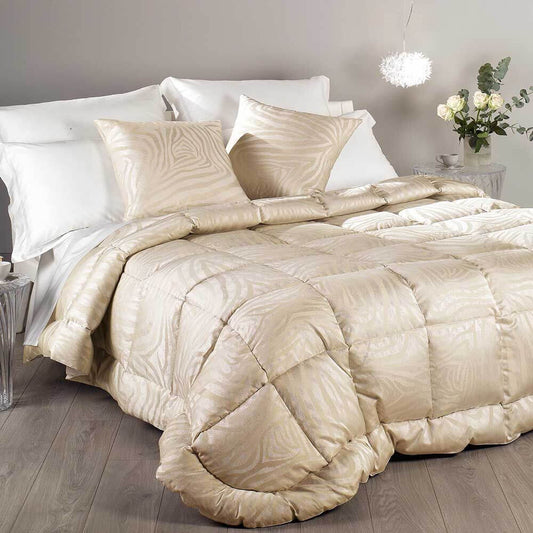 Trapunta invernale matrimoniale Caleffi Serena in prezioso raso jacquard. Imbottitura in pregiata piuma d'oca. Fantasia moderna zebrata, colore oro/beige.