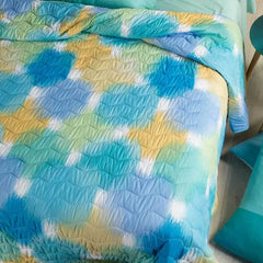 Trapuntino Caleffi Murano in microfibra. Trapunta primaverile caratterizzata da una fantasia moderna, con macchie multicolor stile acquerello, colore bluette verde acqua. Disponibile nella misura per letto singolo, piazza e mezza e matrimoniale.