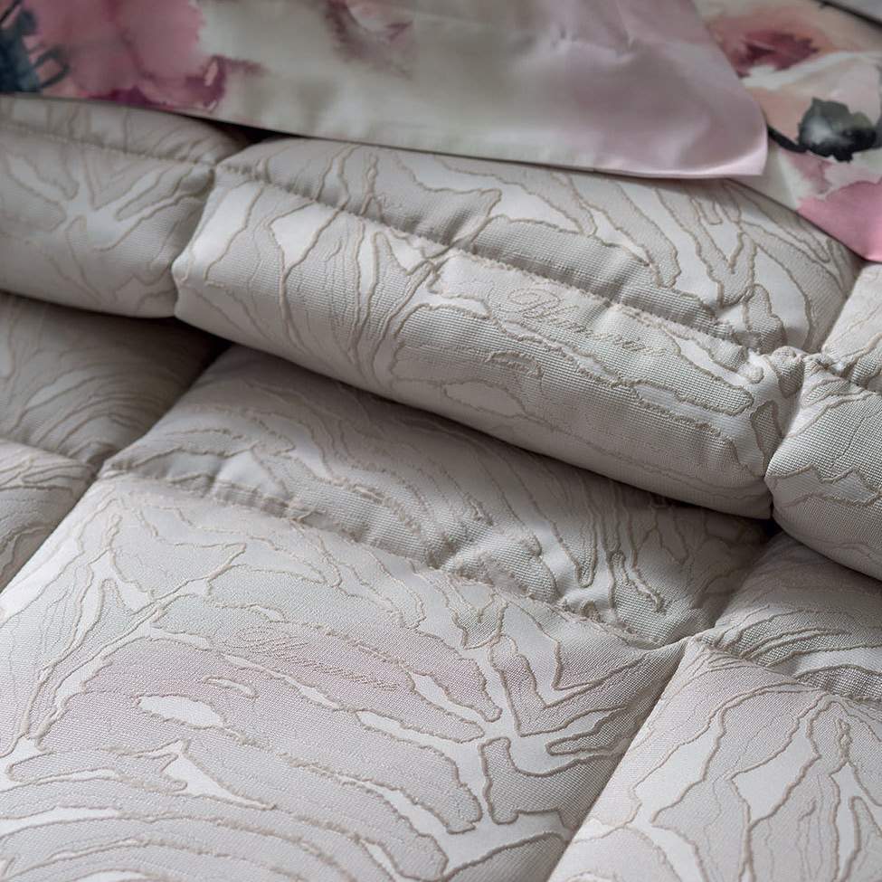 Trapuntino matrimoniale Colette di Blumarine, in elegante raso jacquard. Trapunta primaverile, copriletto con fantasia striata con logo Blumarine nella trama del tessuto. Variante di colore nuvola (beige/tortora).