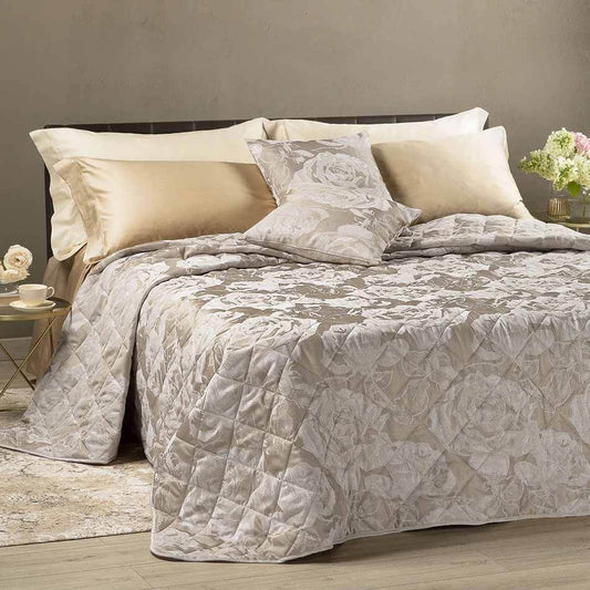 Trapuntino matrimoniale Caleffi Rose in raso jacquard.  La trapunta primaverile Rose presenta una fantasia floreale raffinata ed elegante, con l'effetto lucido del raso jacquard abbinato a rose chiare che risaltano sullo sfondo beige.